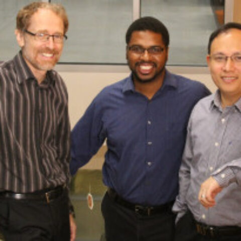 Three men from the Exostellar team pose for a photo on a staircase